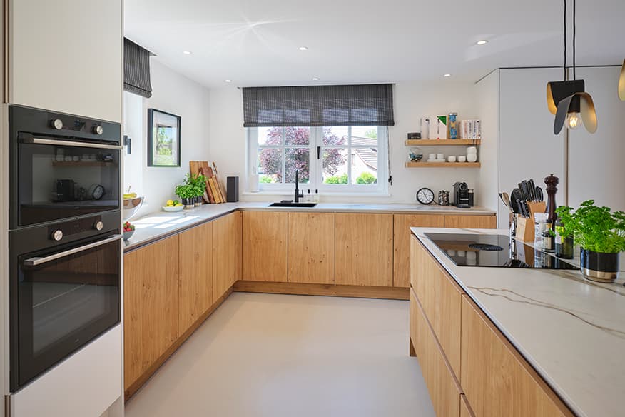 Houten-keuken-met-licht-werkblad-kookeiland-en-hoek