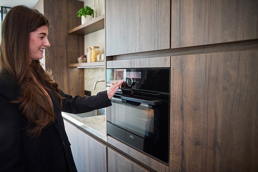 Vrouw-die-oven-bedient-in-moderne-keuken.jpg